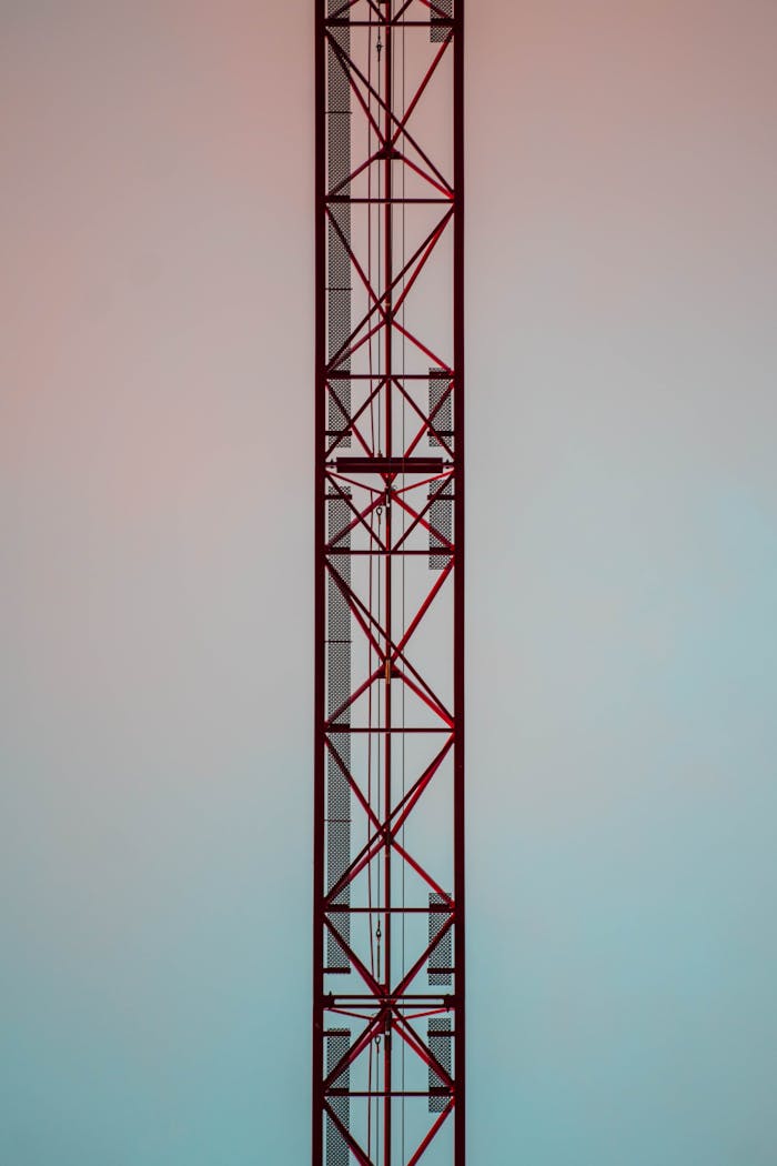 Vertical shot of a tall steel construction tower against a gradient sky.