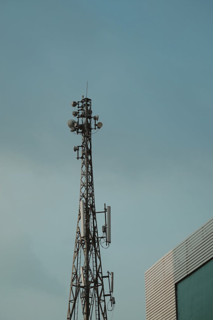 A tall metal telecommunication tower stands against a clear blue sky.